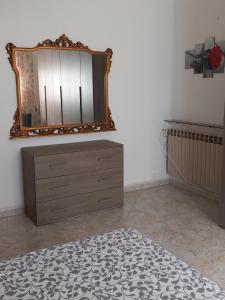 a bedroom with a dresser and a mirror on the wall at la casa di sotto in Alpignano