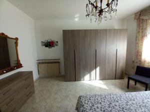 a bedroom with a large wooden cabinet and a mirror at la casa di sotto in Alpignano