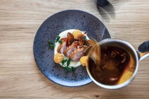 a plate of food with meat and a cup of tea at Hotel Wieser in Campo di Trens