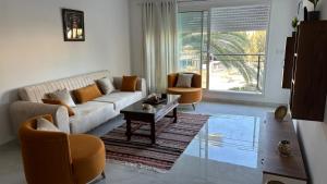 ein Wohnzimmer mit einem Sofa und 2 Stühlen in der Unterkunft Appartement Port El Kantaoui, Kanta Sousse in Sousse