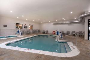 una piscina en un hotel con sillas y mesas en Comfort Suites Colorado Springs East - Medical Center Area, en Colorado Springs