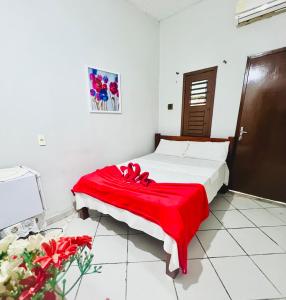 a bedroom with a bed with a red blanket on it at Pousada Cafe e Mar Jeri in Jericoacoara