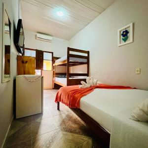 a bedroom with a bed and two bunk beds at Pousada Cafe e Mar Jeri in Jericoacoara