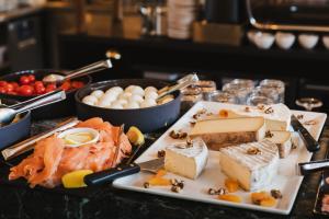 une assiette de nourriture avec du fromage et d'autres denrées alimentaires sur une table dans l'établissement Crowne Plaza Lyon - Cité Internationale, à Lyon