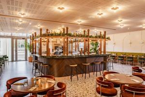 un restaurant avec des tables et des chaises ainsi qu'un bar dans l'établissement Crowne Plaza Lyon - Cité Internationale, à Lyon