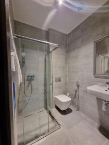 uma casa de banho com um chuveiro, um WC e um lavatório. em Central Hotel em Lviv