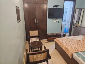 een slaapkamer met een bed en een tafel en stoelen bij Sky Bloom Luxury Homestay in New Delhi