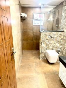 a bathroom with a toilet and a glass shower at Summer House Nandi Foothills in Nandi