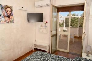 a room with a television and a table with a chair at Casa Donna di Cuori in Fiumicino