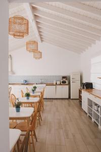 una cucina con tavoli e sedie in legno in una stanza di Pure Fonte Velha B&B a Vila do Bispo