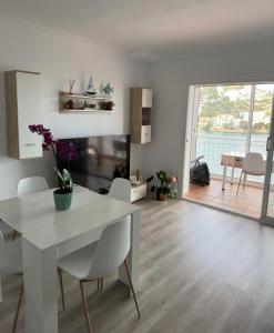 a white dining room with a white table and chairs at Apartamento Canyelles playa in Roses