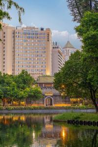 広州市にあるYuexiu Hotel Guangzhou Curio Collection By Hilton - Free shuttle between hotel and Exhibition Center during Canton Fair & Exhibitor registration Counterの高層建築と池のある街並み