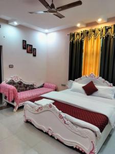 - 2 lits dans une chambre de couleur rose et blanche dans l'établissement Shree Nanda Guest House, à Varanasi