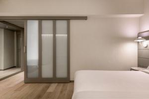 a bedroom with a bed and a sliding glass door at AC Hotel Carlton Madrid by Marriott in Madrid