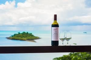 una bottiglia di vino e un bicchiere di vino su una finestra di Amazing Whitsunday Views at High Tide a Cannonvale