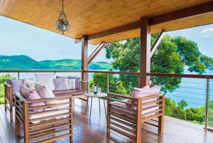 una casa con portico con sedie e vista di Amazing Whitsunday Views at High Tide a Cannonvale