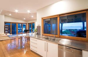 una cucina con lavandino e un soggiorno di Amazing Whitsunday Views at High Tide a Cannonvale