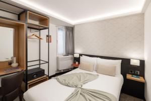 1 dormitorio con cama blanca y escritorio en St Giles London – A St Giles Hotel en Londres