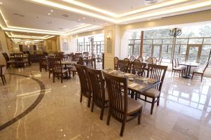 a restaurant with tables and chairs in a room at Amman Paradise Hotel in Amman