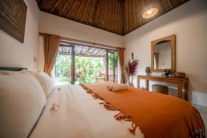 Schlafzimmer mit einem Bett, einem Spiegel und einem Fenster in der Unterkunft Olo Surf Nature in Uluwatu