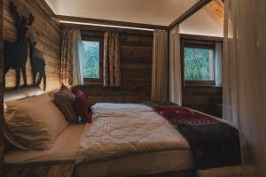 ein Schlafzimmer mit einem Bett in einem Zimmer mit Fenstern in der Unterkunft Rifugio Lago Malghette in Madonna di Campiglio