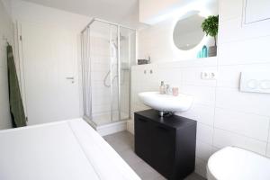 bagno bianco con lavandino e doccia di Blossfeld-Apartments XL-Ferienwohnung Jena Zentrum, 2 Schlafzimmer, W-Lan, Waschtrockner, Smart-TV a Jena