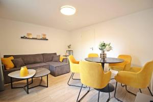 un soggiorno con divano, tavolo e sedie di Blossfeld-Apartments XL-Ferienwohnung Jena Zentrum, 2 Schlafzimmer, W-Lan, Waschtrockner, Smart-TV a Jena