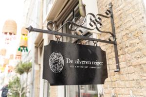 a sign hanging on the side of a building at B&B De zilveren reiger in Middelburg