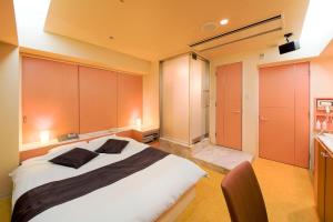 um quarto com uma cama grande e armários laranja em Hotel Public Jam em Osaka