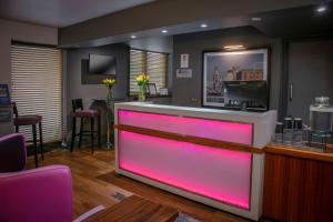 un bar con illuminazione rosa in un barbiere di Heywood House Hotel, BW Signature Collection a Liverpool