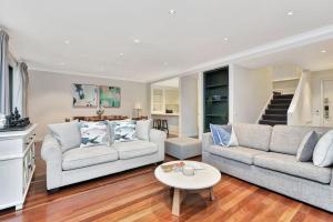 a living room with two couches and a table at Villa 3br Chardonnay Villa located within Cypress Lakes Resort in Pokolbin