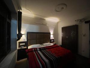 a bedroom with a large bed with a red blanket at Hotel Premier Mall Road Manali in Manāli