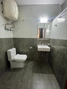 a bathroom with a toilet and a sink at Hotel Premier Mall Road Manali in Manāli