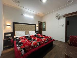 a bedroom with a large bed with a red blanket at Hotel Premier Mall Road Manali in Manāli