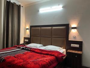 a bedroom with a large bed with a red blanket at Hotel Premier Mall Road Manali in Manāli