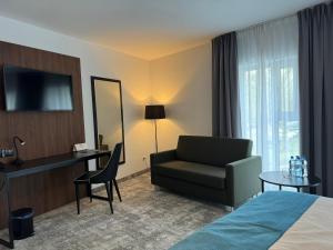 Cette chambre comprend un lit, un bureau et une chaise. dans l'établissement Focus Hotel Premium Lublin, à Lublin