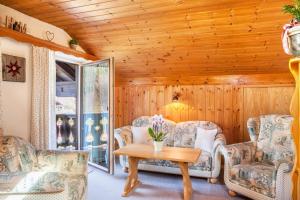 Habitación con sillas, mesa y pared de madera. en Ferienwohnung Lisa Suitner, en Mittenwald