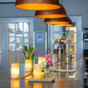 un bar con jarrones de flores sobre una mesa en Hotel Royal, en Noordwijk