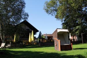 a building with chairs and umbrellas in the grass at Landhotel Ewerts in Insul