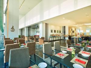 un restaurante con mesas y sillas y un bar en Vivanta Pune, Hinjawadi, en Pune