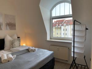 1 dormitorio con cama y ventana grande en RAHA Apartments - Modernes Studio-Apartment - am HBF - kostenloser Parkplatz, en Erfurt