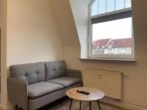 sala de estar con sofá y mesa en RAHA Apartments - Modernes Studio-Apartment - am HBF - kostenloser Parkplatz, en Erfurt