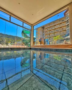 - une piscine intérieure avec vue sur un bâtiment dans l'établissement Hotel Zanon, à Águas de Lindóia