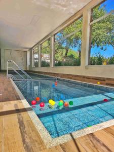 - une piscine avec des balles dans l'eau dans une maison dans l'établissement Hotel Zanon, à Águas de Lindóia