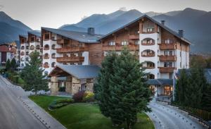 ein großes Gebäude am Straßenrand in der Unterkunft Kempinski Hotel Grand Arena Bansko in Bansko