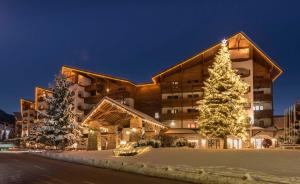 ein Gebäude mit einem Weihnachtsbaum davor in der Unterkunft Kempinski Hotel Grand Arena Bansko in Bansko