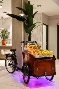 uma bicicleta com um carrinho cheio de frutas e legumes em Leonardo Royal Hotel Amsterdam em Amesterdão