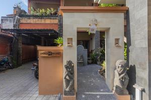 a building with two statues on the side of it at Donahome in Sanur