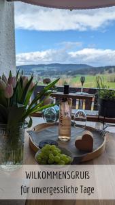 une table avec une plaque de raisin et une bouteille dans l'établissement Ferienwohnung Alpenflair mit Pool und Sauna & direkt am Skilift, à Missen-Wilhams