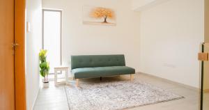 a green chair in a living room with a rug at Luxury Villa by the sea in Fujairah